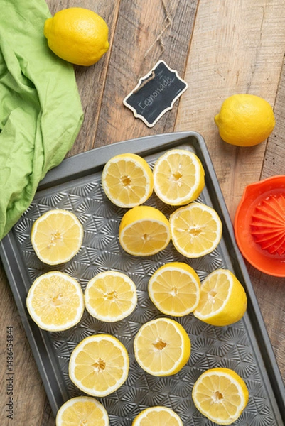 Obraz Lemons cut in halves on a baking sheet, preparing to make lemonade.