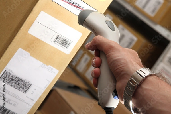 Obraz Man with barcode reader works on warehouse