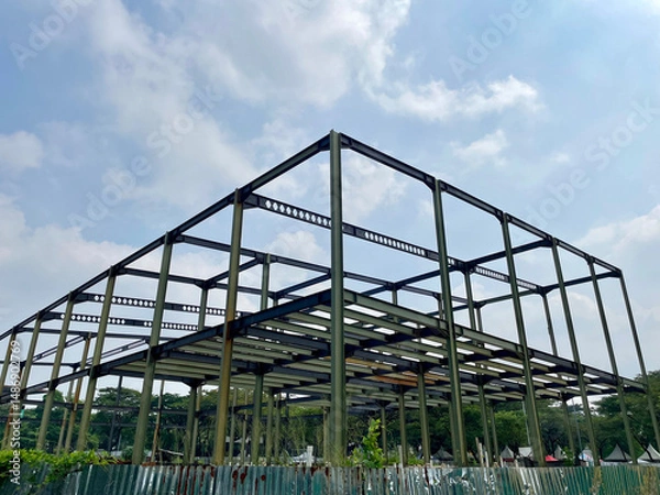 Fototapeta Building frame with a series of iron frames and at the bottom corrugated zinc sheets with a blue sky background