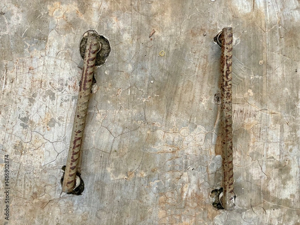 Fototapeta Two iron rods embedded in the grey cast floor, iron handle concept for drainage control tank