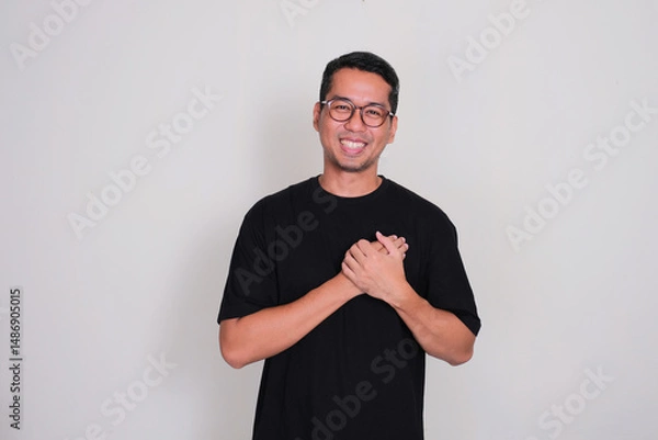Fototapeta A man smiling happy with hands touching his chest