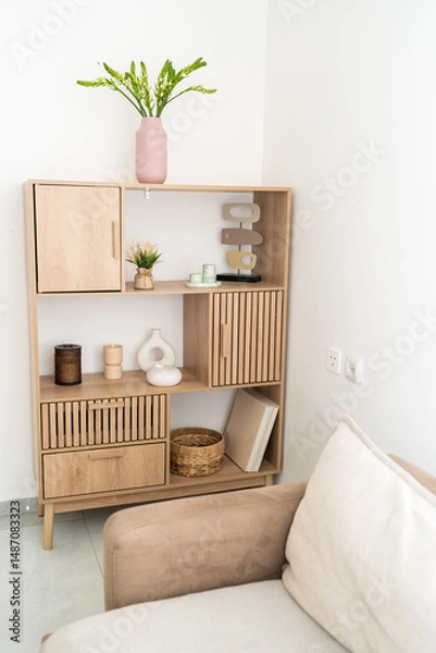 Obraz A wooden shelf in a minimalistic interior displays various decorative items and plants. Soft lighting accentuates the natural wood texture and creates a welcoming atmosphere.