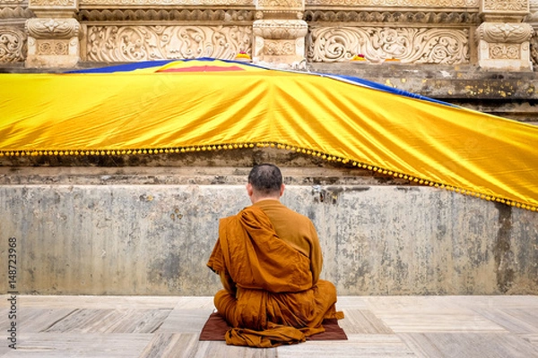 Obraz Buddhist monk praying and meditating at the base of Bodh Gaya Stupa, Gaya, India.