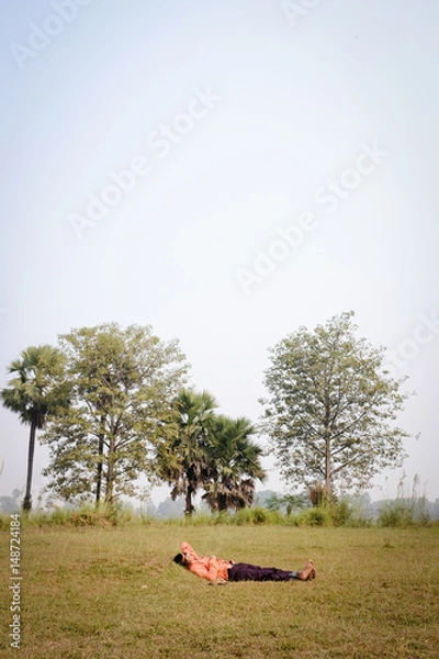 Obraz Indian man sleeping on the grass in the middle of the day.