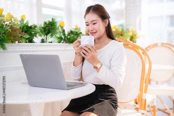 Obraz Portrait of beautiful happy Smiling  of hands Holding cup mug of Hot coffee latte wits business female casual working with laptop computer in coffee shop like the background,communication concept