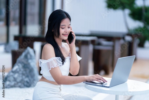 Obraz asian freelance people teenage businesswoman talking making using smartphone casual working with laptop computer in cafe coffee shop background,business expressed confidence embolden and successful