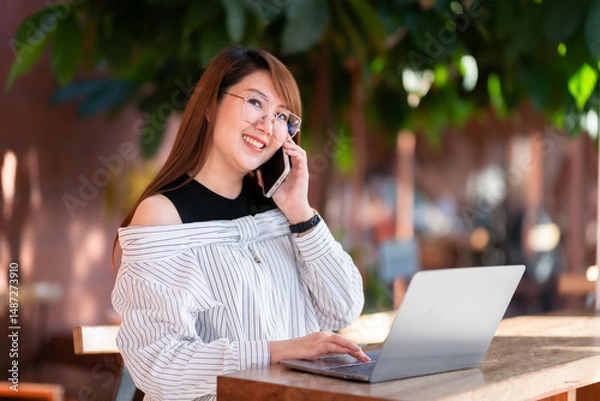Obraz Happy of asian freelance people business female talking making using smartphone casual working with laptop computer and coffee cup in at the cafe, Business Lifestyle communication concept