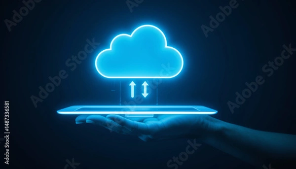 Fototapeta A glowing cloud icon with upload and download arrows hovering above a digital tablet held in a hand, symbolizing cloud computing, data storage, and technology innovation.
