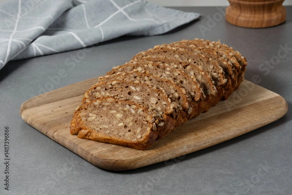 Fototapeta Sliced rye bread on cutting board. Whole grain rye bread with seeds