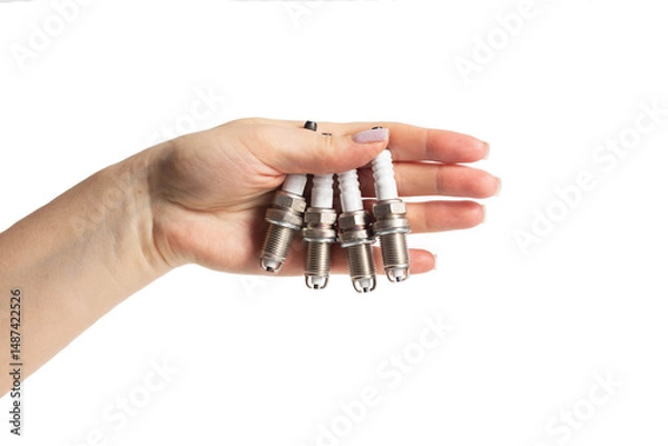 Fototapeta Car spark plugs in a girl's hand on a white background, isolate. Close-up