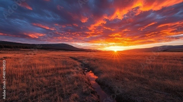 Fototapeta Cracked Dry Field Beneath a Dramatic Sunset