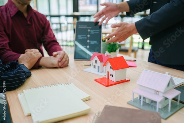Obraz Real estate sales agent explain rental or buying condition to young couple before move to new home or apartment at real estate sales office. Asian urban lifestyle or real estate business concept.