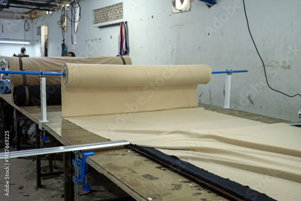 Fototapeta process of cutting rolls of material in a clothing factory, textile and industry concept.