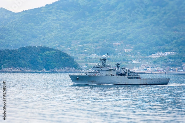 Fototapeta A South Korean navy frigate in grey camouflage returns to base after a coastal patrol mission near the port of Busan – a quiet moment after completing its maritime duty.