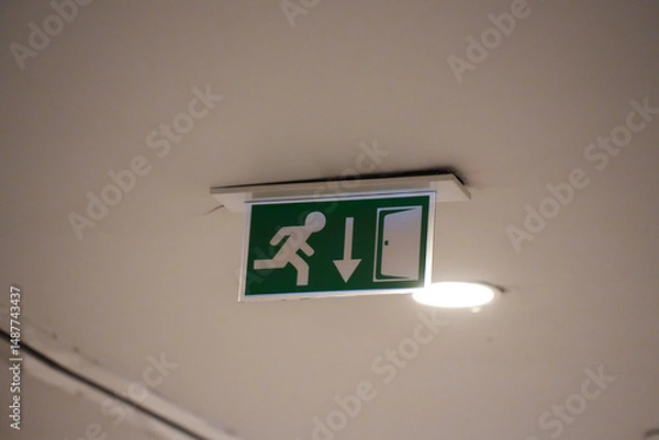 Fototapeta emergency exit sign on a wall