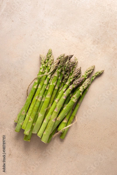 Fototapeta Overhead view of Fresh green asparagus on stone surface