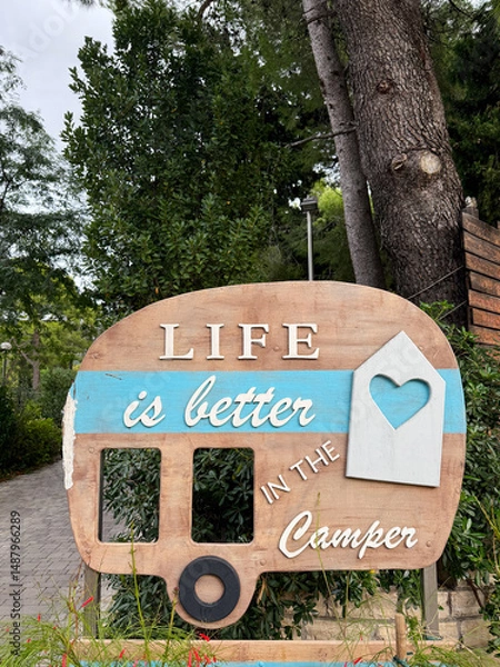 Fototapeta Life is better in the camper: wooden sign promoting van life and camping holidays