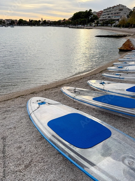 Fototapeta Transparent paddle boards resting on the beach at sunset in Fazana, Istria