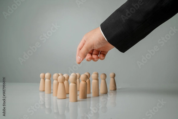 Obraz Hand Choosing Wooden Figures on Surface for Business Decision Making