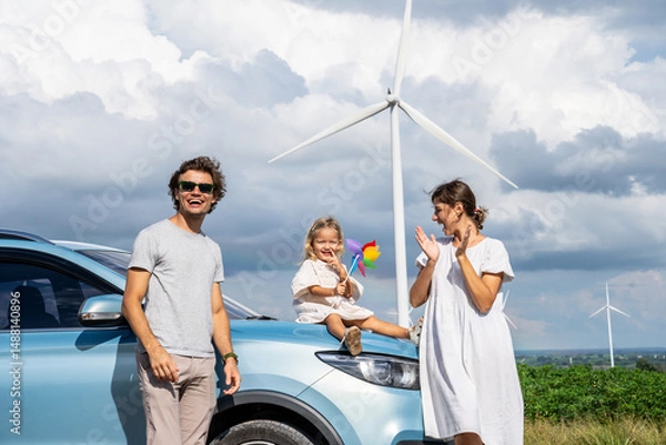 Obraz Concept of progressive happy family holding windmill toy and relax at wind farm with electric vehicle, happy family in the community with wind generators turbines, ev car