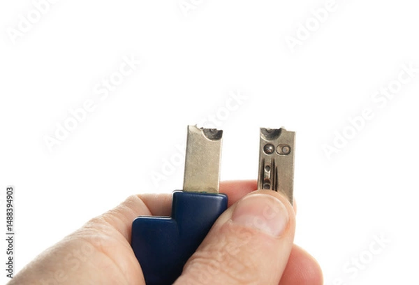 Fototapeta Person holding broken key. Key snapped in two pieces. House key for residential building. Locksmith or handyman needed for lock malfunction or key replacement. Selective focus. White background.