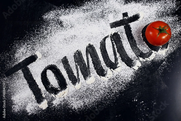 Obraz The inscription on the flour. Tomato. Black background