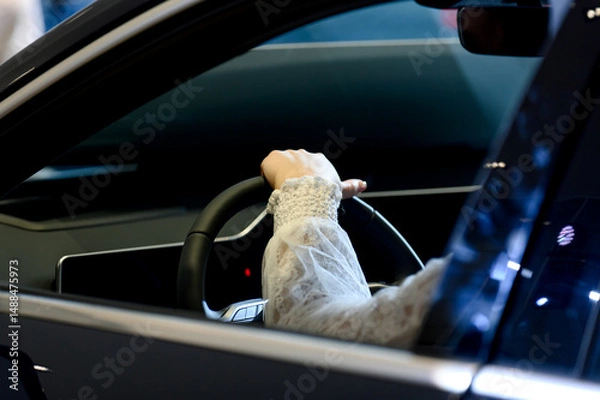 Fototapeta close-up of a man sitting behind the wheel of a new car