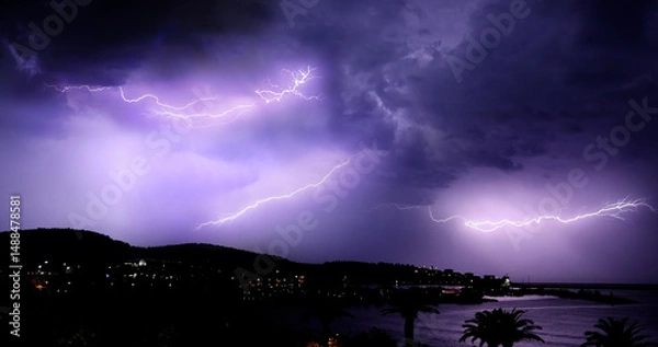 Fototapeta Lightning storm over Adriatic sea. Sky with lightning bolt and silhouette of a cityscape at night. Bar in Montenegro