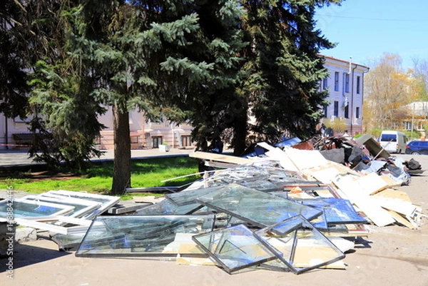 Obraz War in Ukraine. Broken windows piled up in destroyed house after Russian missile strike, Broken glass, debris of building