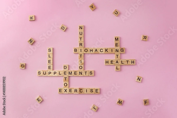 Fototapeta Crossword on concept of biohacking made of wooden blocks with letters on pastel background. Selective focus