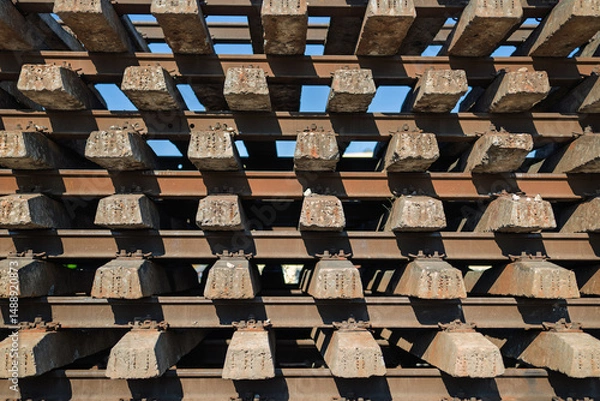 Fototapeta Massive pile of railroad sleepers arranged for industrial rail maintenance, emphasizing scale and transportation infrastructure.