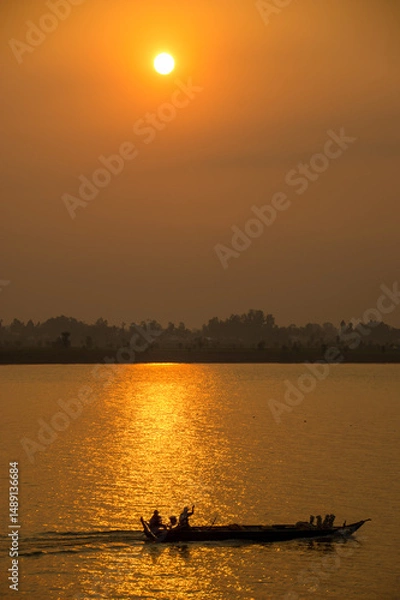 Obraz Golden sunset on the Mekong River with a boat in the foreground 