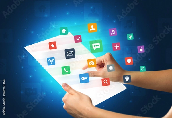Fototapeta Hands touching a glass-like tablet with colorful icons