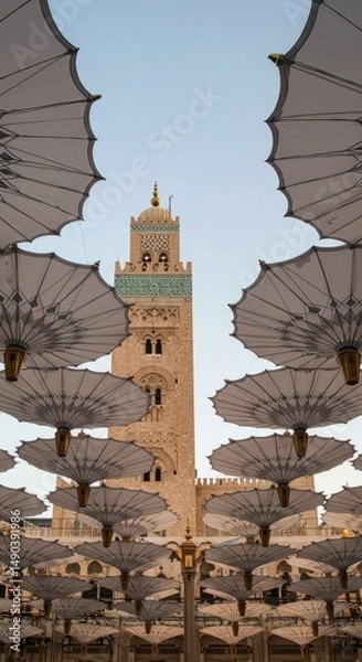 Obraz Magnificent Mosque Minaret Viewed Through Array of Elegant Umbrellas in Morocco