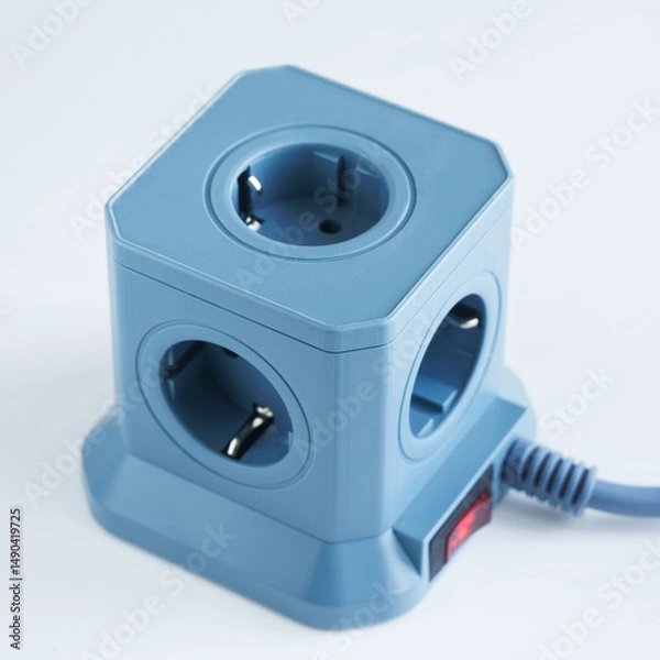 Fototapeta A blue cubic power strip featuring four euro sockets and an illuminated red switch, ideal for organizing and powering multiple home or office electronics without clutter. Photo