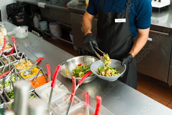 Obraz Cook preparing a fresh salad at salad bar restaurant