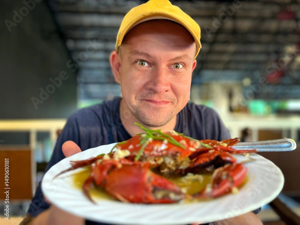 Fototapeta happy man showing crab on plate