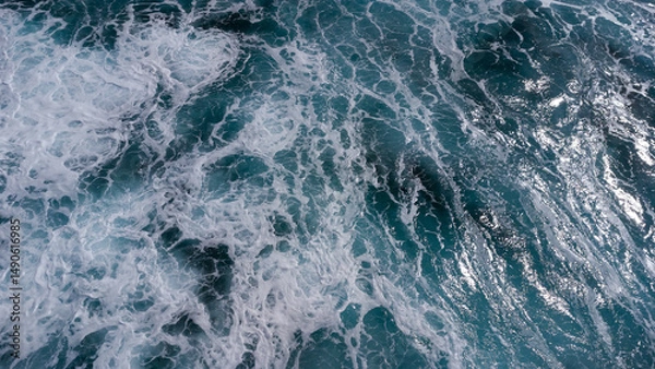 Fototapeta ocean surface foaming from waves, texture and shape of sea water, aerial view