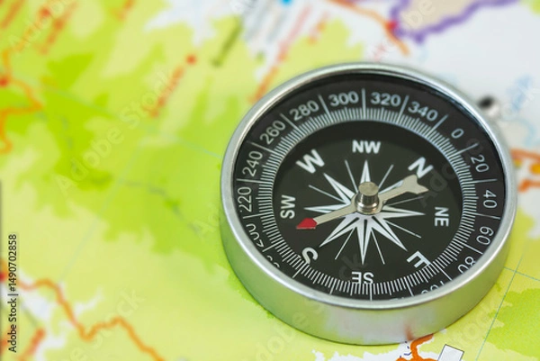 Fototapeta selective focus of compass on blurred map background.