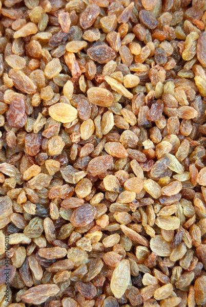 Fototapeta Close-up of dried grapes background. Raisins background. Yellow raisins close-up. Brown raisin texture.