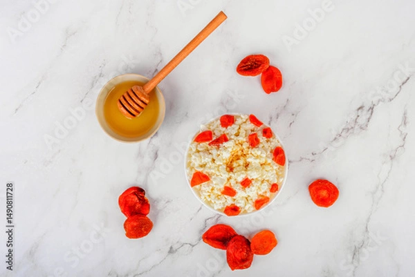 Obraz Top view of fresh cottage cheese with dried apricots and honey.
