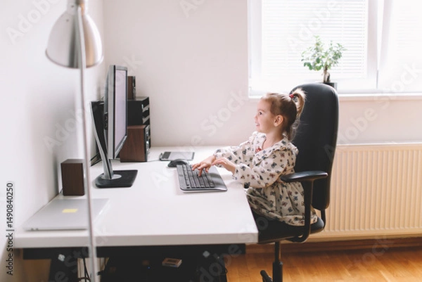 Fototapeta Little girl typing on computer