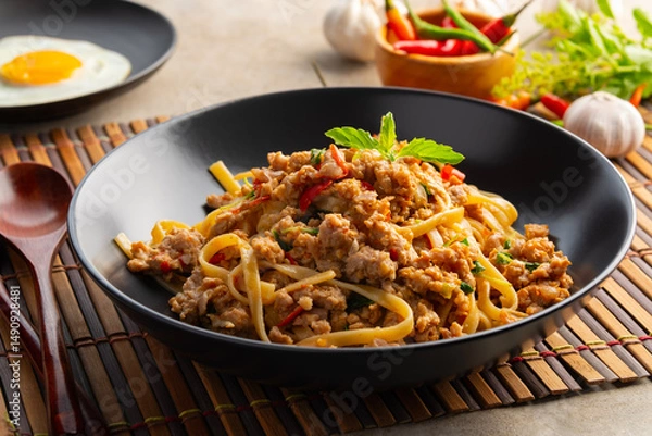Fototapeta Stir fried spicy fettuccine pasta with minced pork and basil in black plate,Spaghetti Pad Kra Pao.
