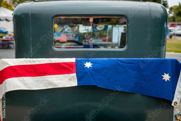 Fototapeta US flag draped over the trunk of a classic car