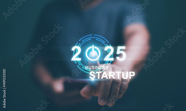 Fototapeta Business startup concept. Businessman touch turn on icon for start new business on 2025. Planning and strategy business start and growth to success or rising successful development in the future.