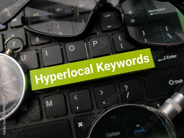 Fototapeta Compass and glasses with the word Hyperlocal Keywords on a black keyboard background