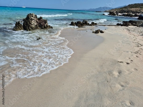 Obraz white sand, a few rocks and crystal clear water at the beach of plage de saleccia in corsica