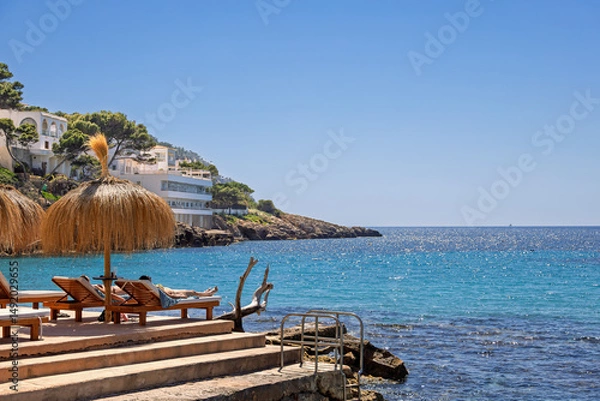 Obraz Women sunbathing on a terrace on a beach with a beautiful sea view