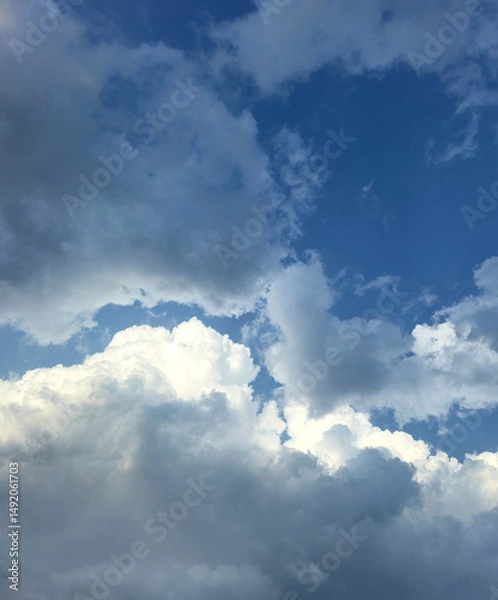 Obraz Summer blue sky cloud gradient light white background. Beauty clear cloudy sky. Sun shining through the puffy clouds. Beautiful sunny dynamic sky. Background with clouds on blue. Art of clouds