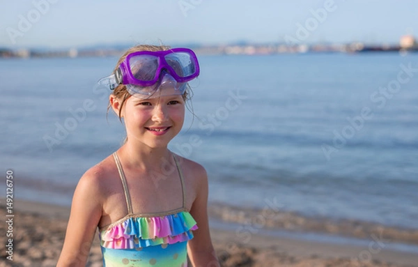 Fototapeta Young girl with snorkeling goggles enjoying a day at the beach